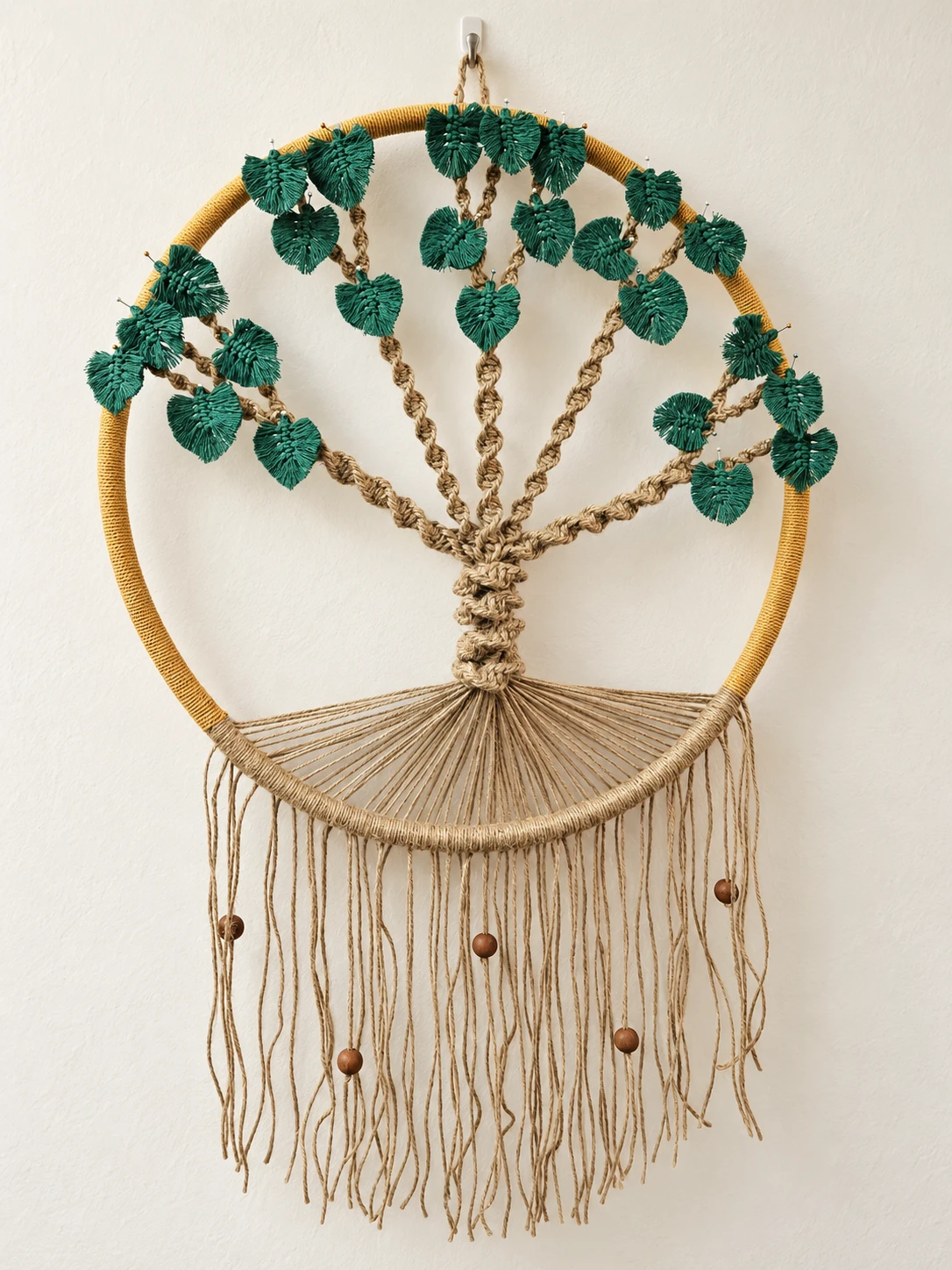 Circular macramé tree with green leaves and a beaded fringe